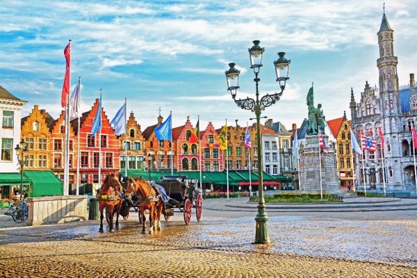 Horse-carriages-on-Grote-Markt-square-in-medieval-city-Brugge-at-morning-Belgium.-min